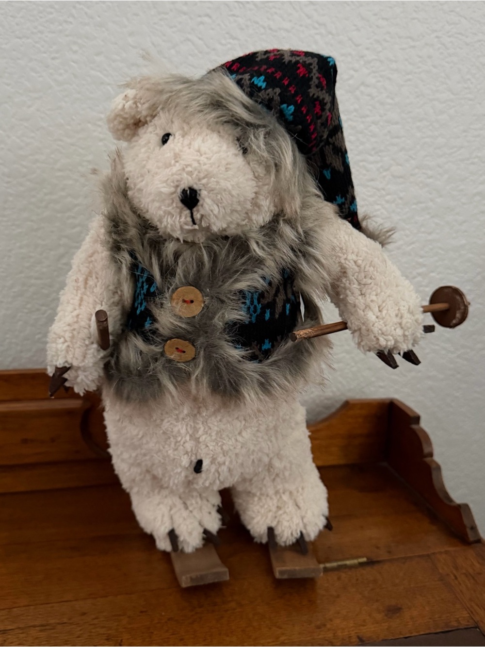 Winter forest fabric bear with blue coat and skis.